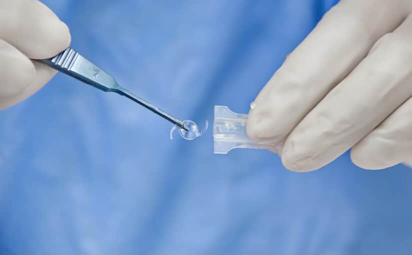 Doctor removes an IOL and prepares to place it in a patient’s eye