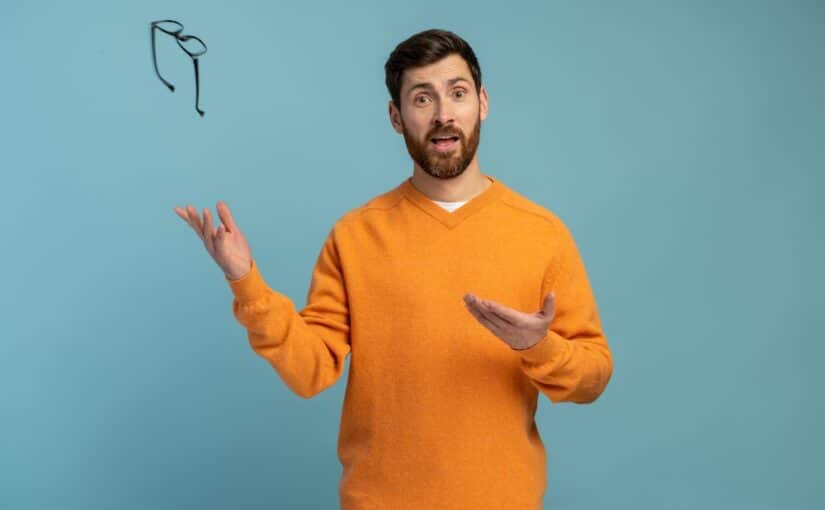 Young man in orange shirt tosses his glasses away